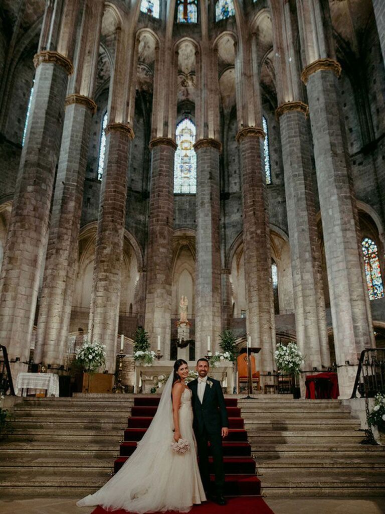 Bride and groom posing in gothic cathedral at dark academia wedding