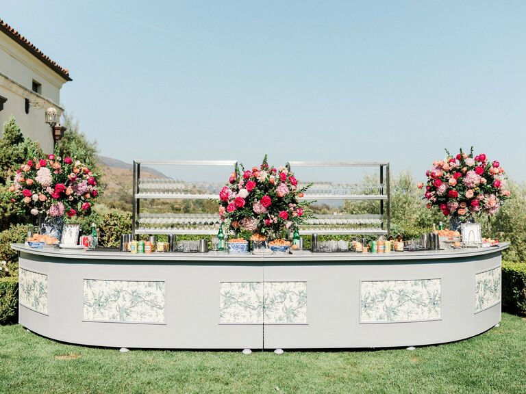 Curving outdoor bar service space with floral arrangements
