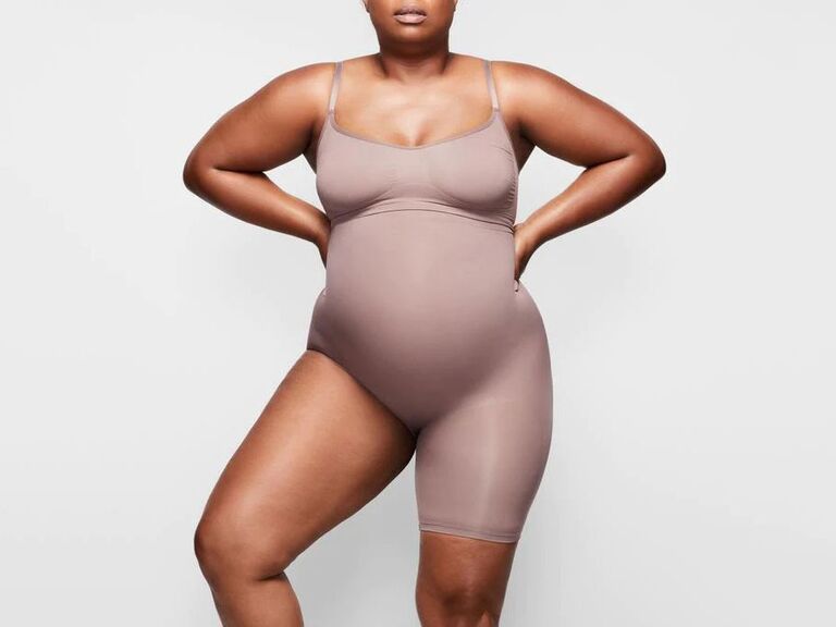 Model wearing umber-toned one-leg shorts bodysuit wedding shapewear