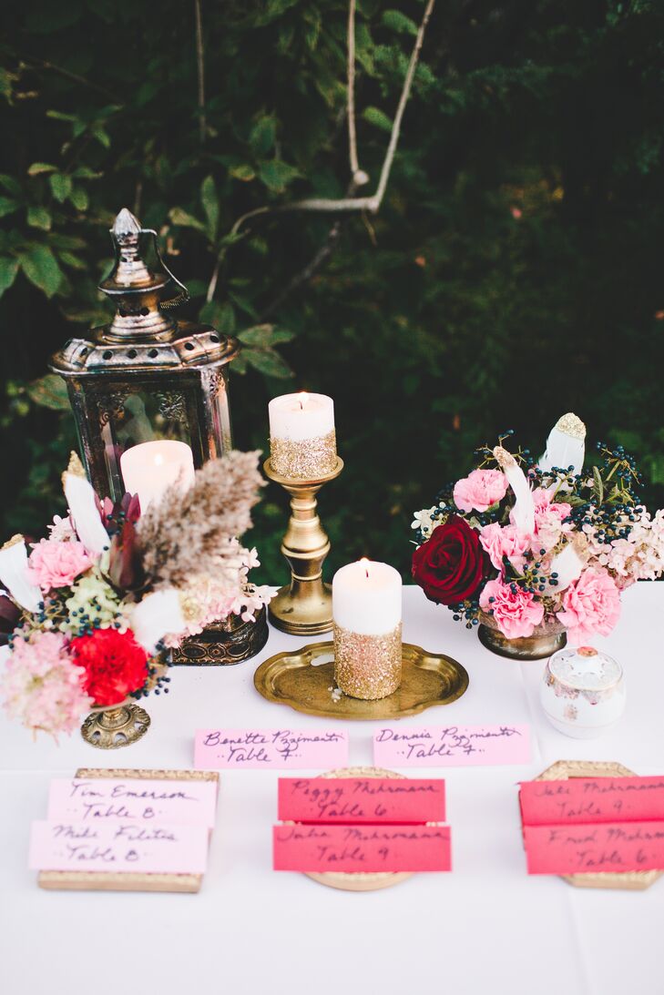 Pink escort cards waited at a table decorated with found objects in metallic colors.