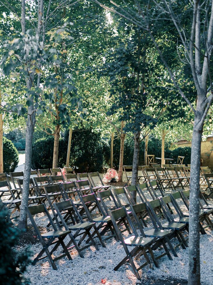 Wooden Chairs Amongst Trees With Minimal Pink Flowers for Ceremony