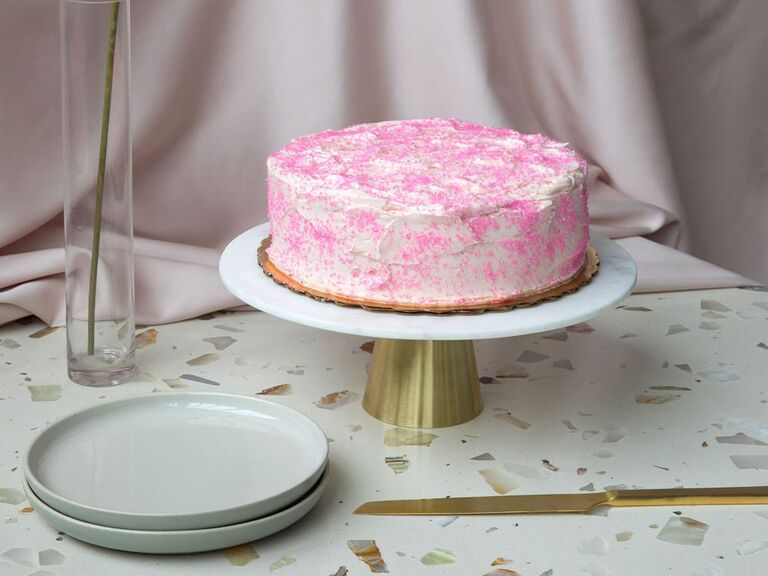White and gold marble wedding cake stand with single-tier pink and white cake
