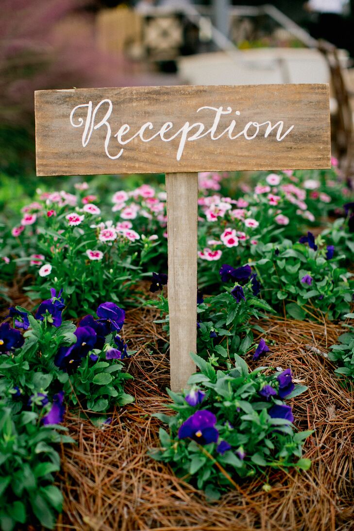 Wooden signs embellished with calligraphy add a rustic touch to Amanda and Alex’s nautical waterfront reception at Figure 8 Island Yacht Club in Wilmington, North Carolina.