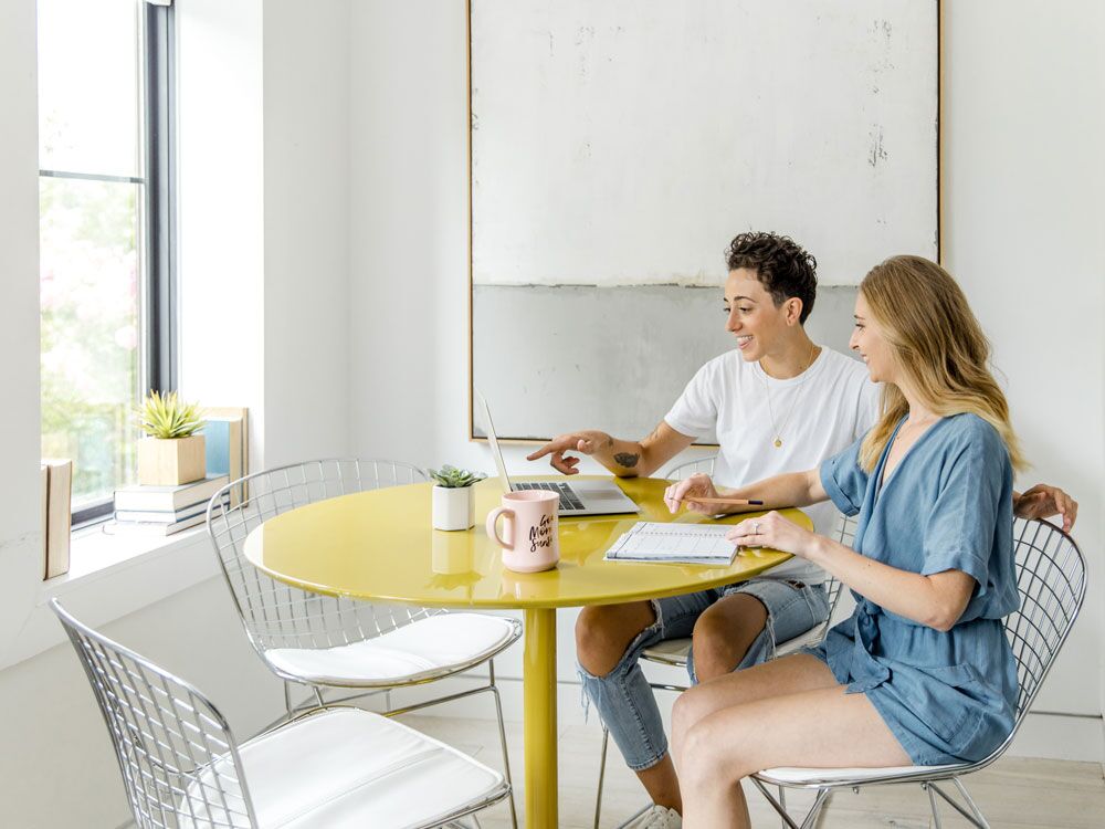 Engaged couple planning wedding on laptop at home