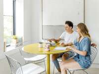Engaged couple planning wedding on laptop at home
