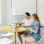 Engaged couple planning wedding on laptop at home