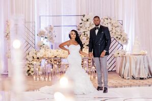 Bride and Groom Posing in Reception Ballroom Beside Glam Decor
