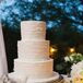 Lindsey and Daniel's wedding cake was simple and classic: It had three round tiers covered in textured white buttercream atop a textured metallic gold cake stand. Ivory flowers and greenery surrounded the cake display. "It was important for the cake to feel like we made it at home," Lindsey says.