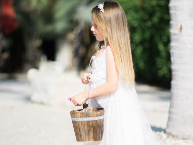 Flower girl wears her hair in a sleek straight style. 
