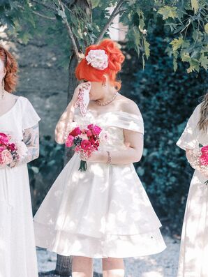 Bridesmaid in Tea-Length White Dress With Pink Bouquet Dabs Eyes at Ceremony