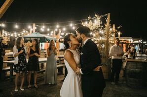 The Bride and Groom Share Kiss Underneath String Lights During Wedding Reception