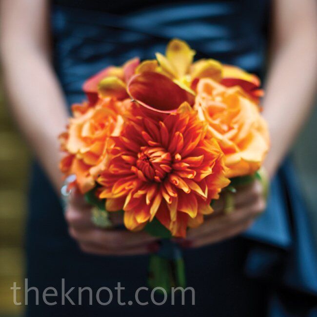 Brightorange dahlias, calla lilies, roses and orchids really popped against the gray-blue bridesmaid dresses.