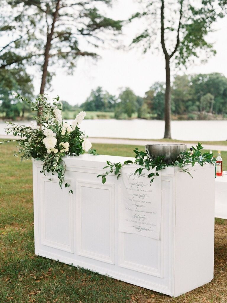White bar top with greenery for outdoor wedding reception space