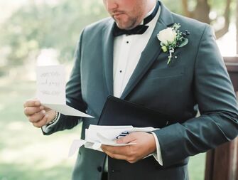 A groom reads a letter from their spouse on their wedding day.