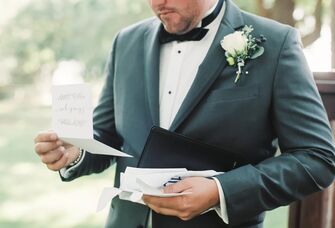 A groom reads a letter from their spouse on their wedding day.