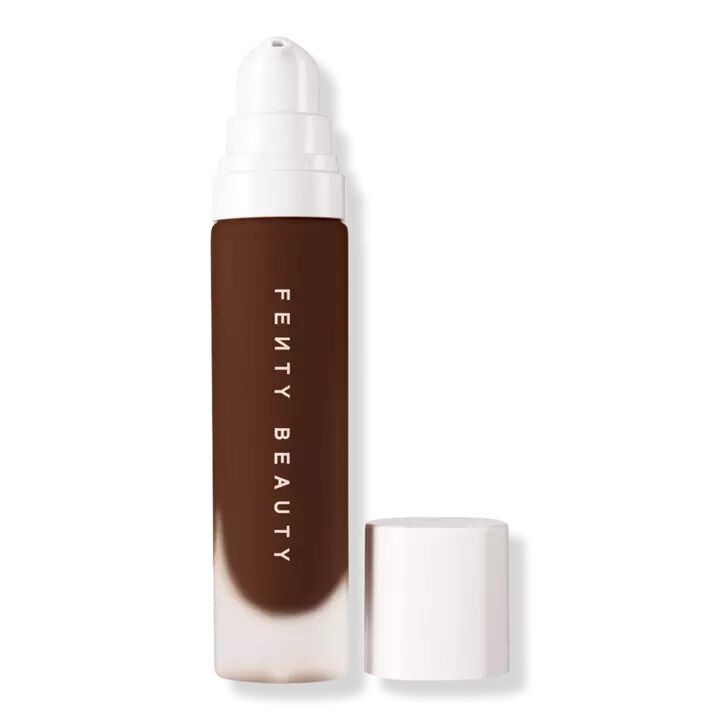 Glass bottle of Fenty Beauty foundation in a dark shade. 