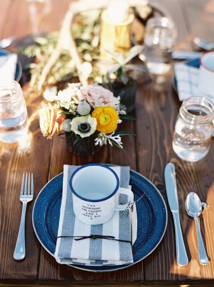 Centerpieces included floral arrangements in bark and tin containers, antler sheds, and wooden candleholders (custom-made by the bride's brother from reclaimed logs). On top of the place setting was the favor: an enamel mug with one of three sayings: “The mountains are calling and I must go,” “Oh darling, let's move to Montana and be adventurers” and “Paddle your own canoe.”