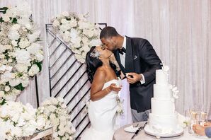 Couple Sharing Kiss During Wedding Cake Cutting