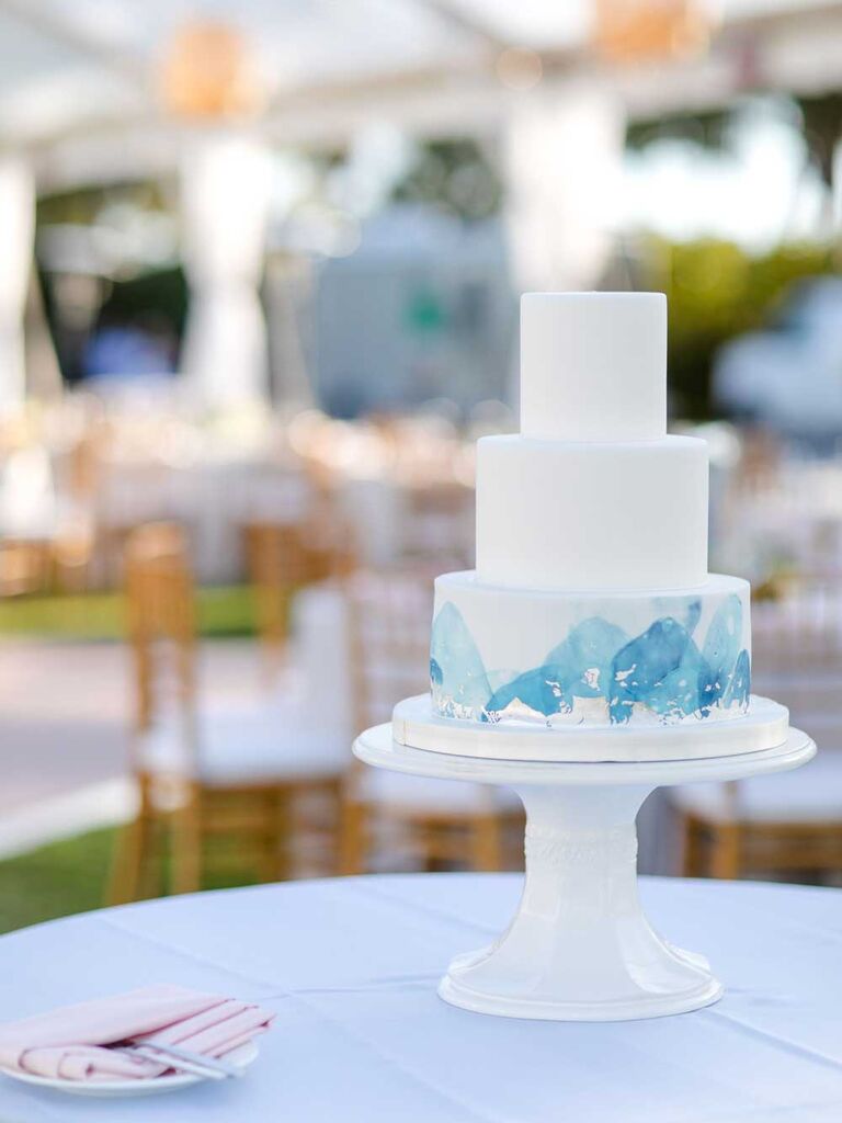 White tiered wedding cake with blue watercolor design