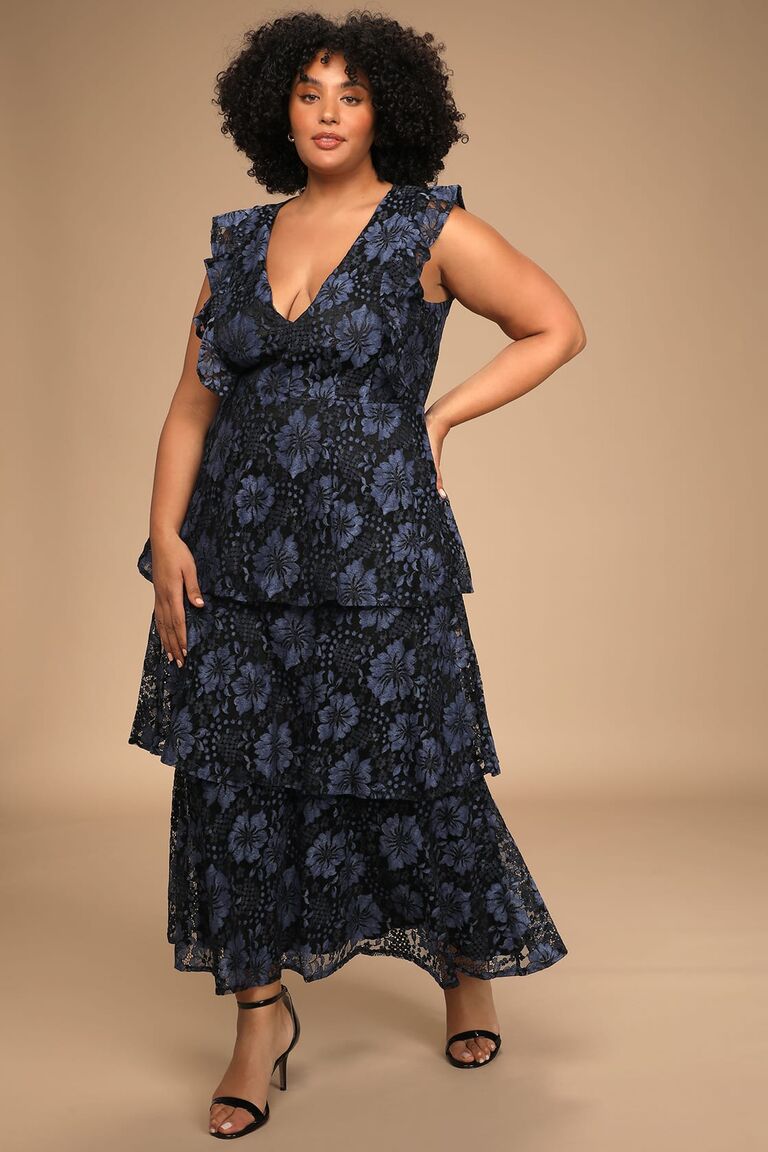 Model wears a mid-length gown with ruffled tiers. 