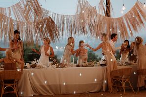 Brides Toasting With Friends, Family at Minimalistic Head Table Under Tassel Banner