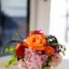"I like to paint with bright, clean colors," Amy says. "We added in a touch of some other colors to make the arrangements pop." Each cocktail table was paired with a fun floral linen and bright centerpieces of orange, red and pink roses, pink hydrangeas, purple veronica and greenery. Each was designed by Garden District-Naples.