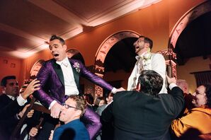 Grooms in Fashion-Forward Purple-and-White Tuxedos Hoisted in Chairs During  Hora, Jewish Reception