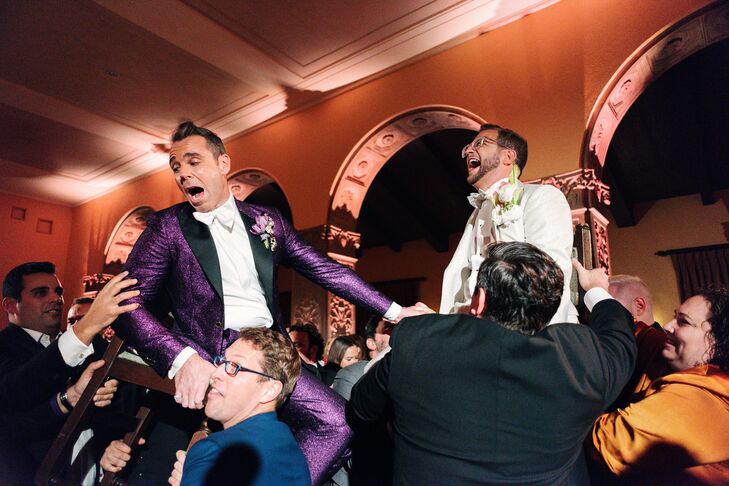 Grooms in Fashion-Forward Purple-and-White Tuxedos Hoisted in Chairs During  Hora, Jewish Reception