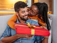 Couple hugging exchanging gift for husband from wife