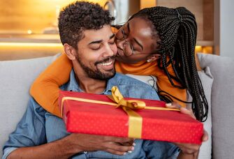 Couple hugging exchanging gift for husband from wife