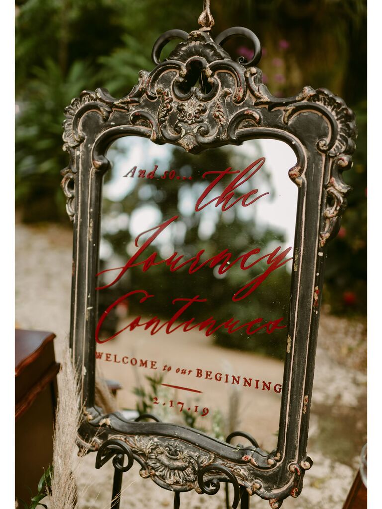 Red calligraphy wedding signage on vintage baroque mirror