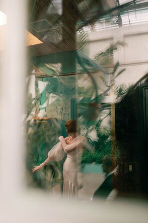 Artistic Film Through Window of Bride Putting on Detachable Sleeves Before Wedding