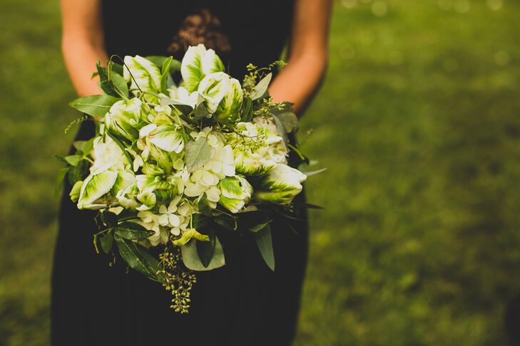 Bridesmaids in black carried bouquets of greens, white hydrangeas and green hypercium.