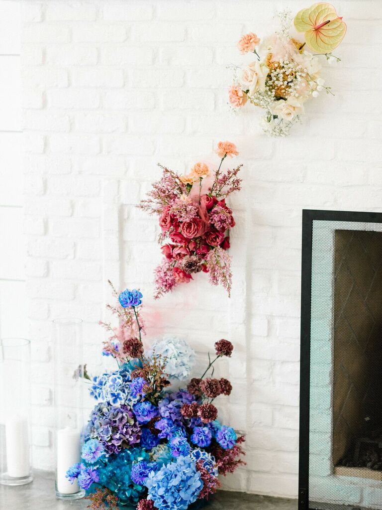 A blue, pink and yellow flower wedding installation.