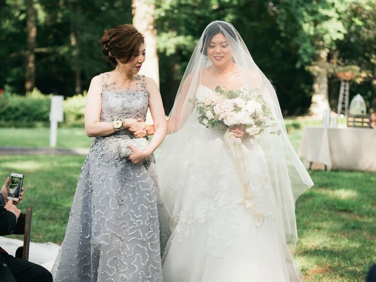 Mother walks her daughter down the aisle on her wedding day. 