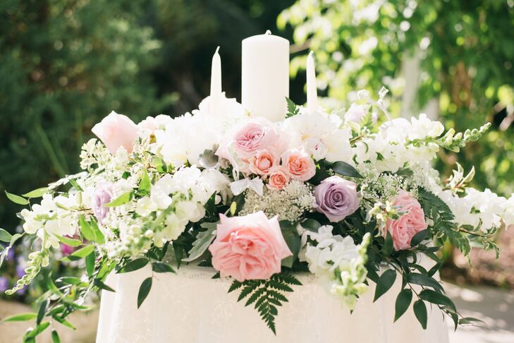 Nicole's mother, a local florist, grew many of the blooms used throughout the big day. The couple's unity table was especially lavish with garden roses and ferns.