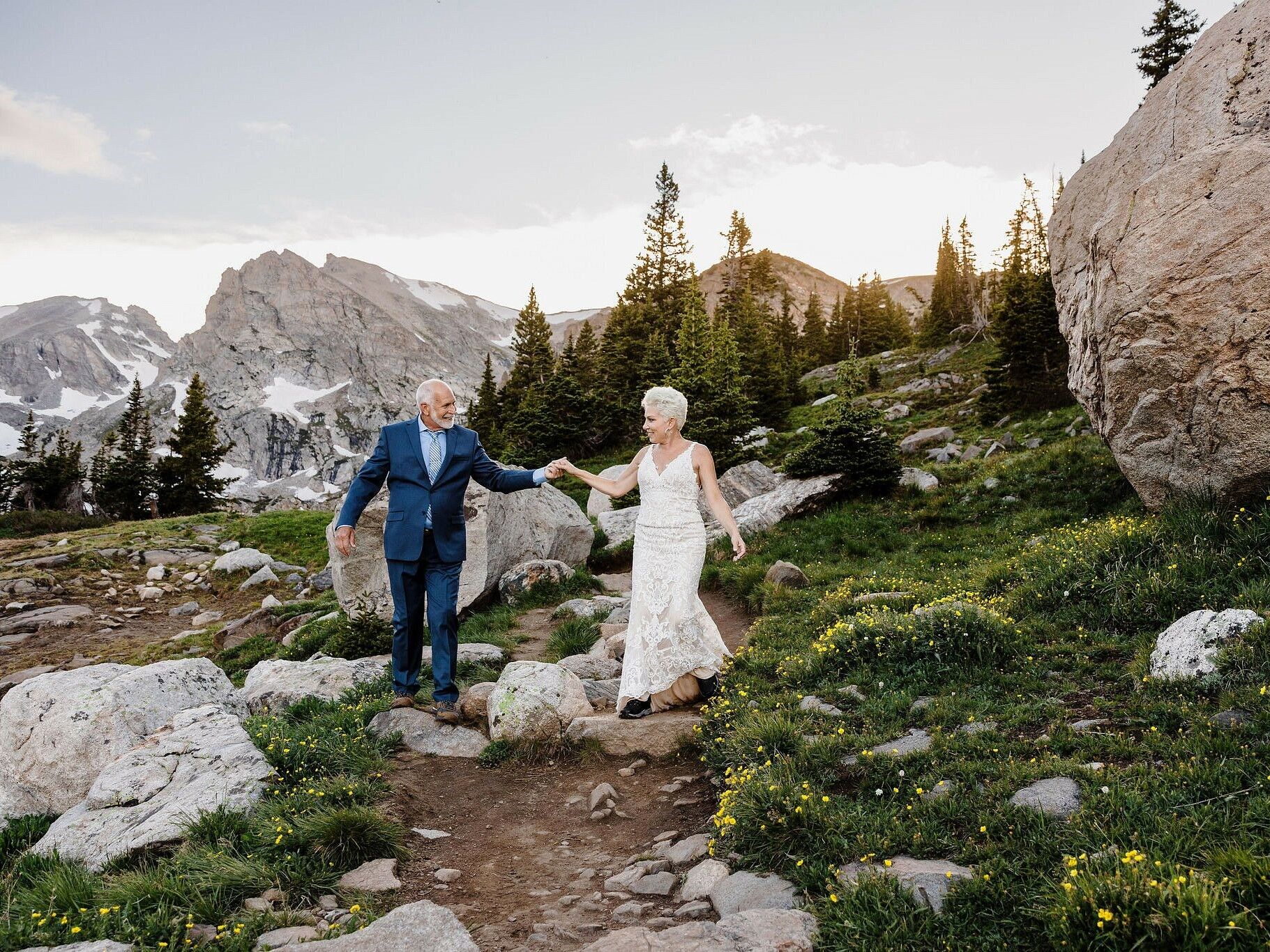 A couple renews their vows at a beautiful outdoor ceremony in the mountains. 
