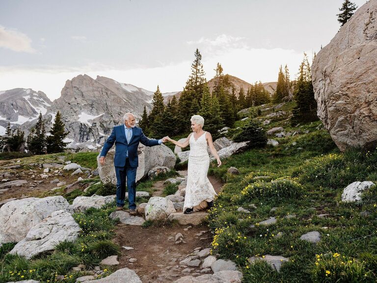 A couple renews their vows at a beautiful outdoor ceremony in the mountains. 