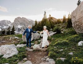 A couple renews their vows at a beautiful outdoor ceremony in the mountains. 