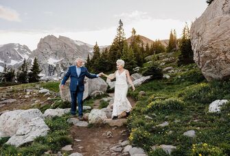A couple renews their vows at a beautiful outdoor ceremony in the mountains. 