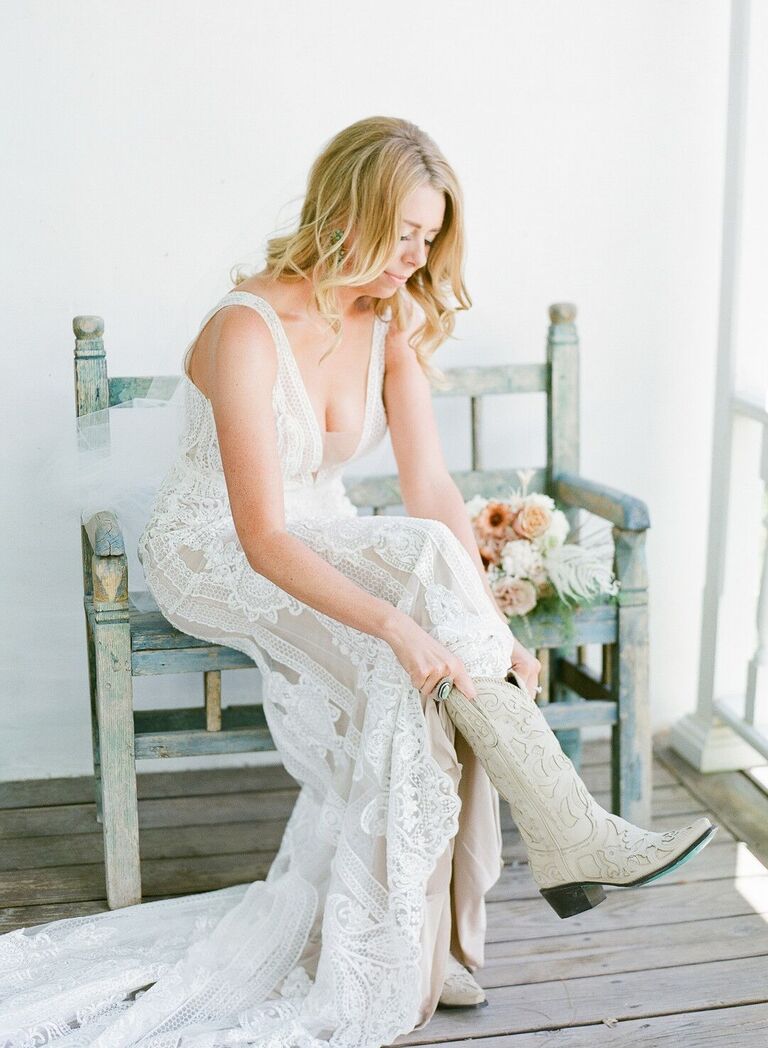 Bride pulling on white cowboy boots