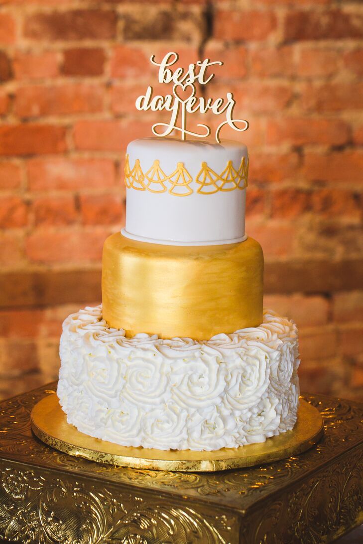 Marianne and John's white and gold wedding cake was decorated differently at every tier. The bottom layer featured white rosettes, the middle layer was painted gold, and the top layer was white with gold piping. In keeping with the theme, the cake was topped off with a 'best day ever' topper.