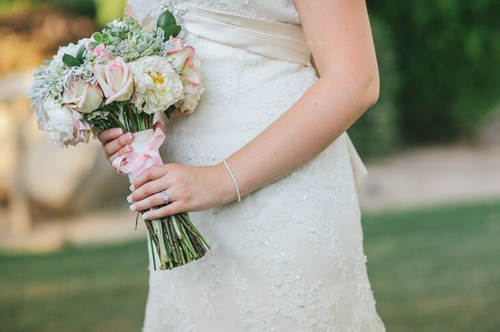 The couple chose a pale pink color palette that introduced a softness to the wedding's rustic ranch details. Pale pink roses and white peonies paired with rustic accents like dusty miller filled Madison's bridal bouquet.