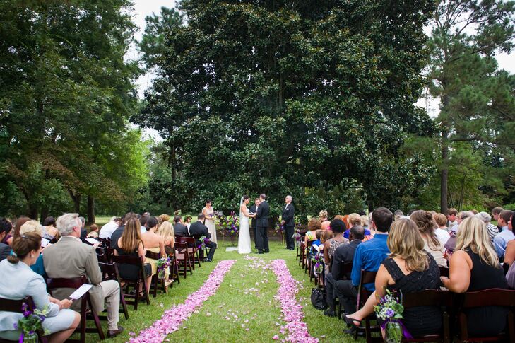 The outdoor ceremony aisle was lined with loose purple petals and wooden folding chairs.