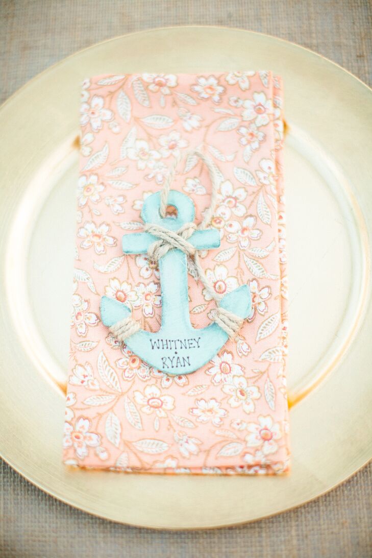 The reception tables were dressed in white and burlap linens for a bit of beachy flair, with gold chargers and coral floral napkins introducing touch a color and island glamour to the decor.rn