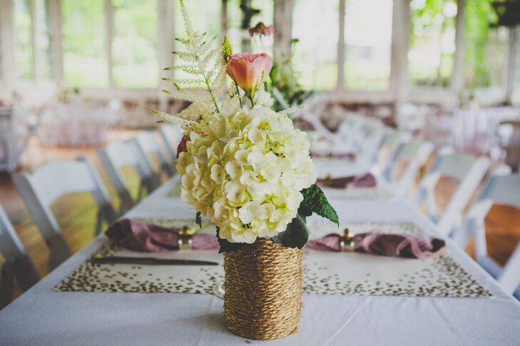 At the reception, table centerpieces were decorated with hydrangeas and garden roses arranged inside vases wrapped with twine, which were made by the bride.