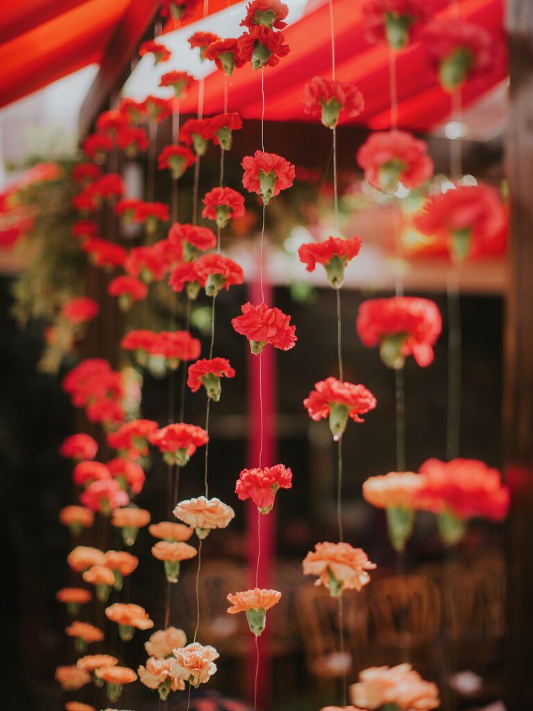 flower curtain made from strands of red, orange and peach marigolds on clear fishing line