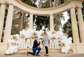 Man proposing to woman in front of 'Marry Me' sign in Orlando