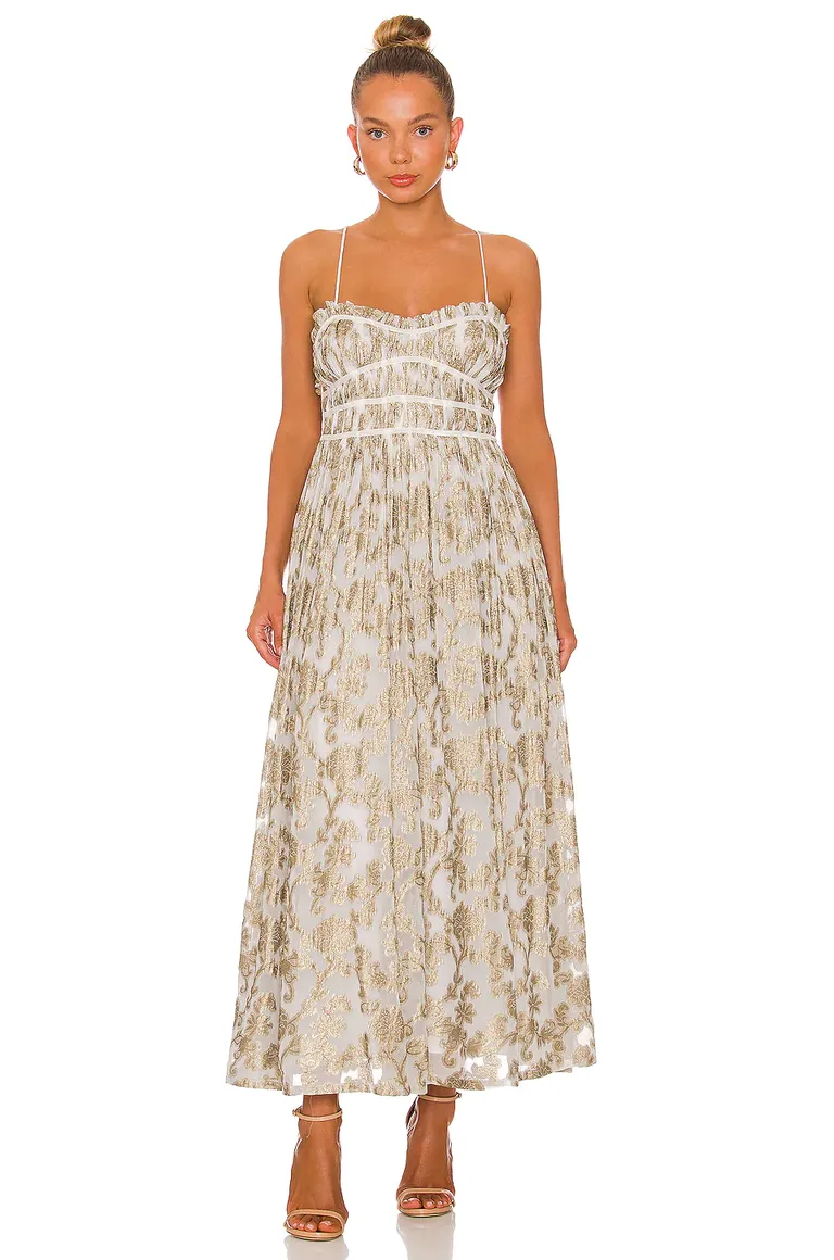 Model wears a shimmery white and gold floor-length dress.