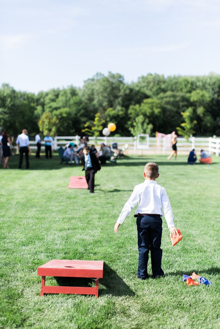 Guests sipped cocktails and played cornhole during the outdoor cocktail hour on the sprawling lawn at Wildwood Family Farms in Alto, Michigan.